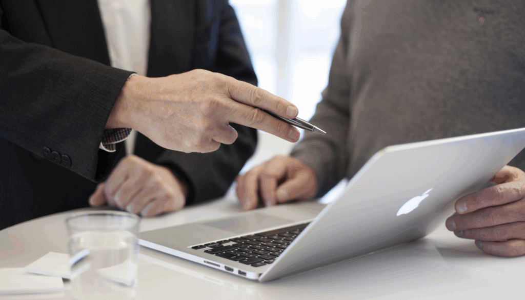 professionnel qui montre un element sur un mac à une autre personne